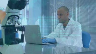 Bilgisayarı kullanarak Afrika kökenli Amerikalı erkek laboratuvar çalışanı üzerinde bilimsel verilerin animasyonu. Bilim, sağlık, tıp ve teknoloji konsepti dijital olarak üretilen video.