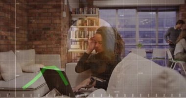 Animation of financial data over biracial businesswoman working on laptop in office. economy, finance, business and technology concept digitally generated video.