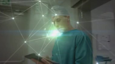 Tablet kullanan beyaz erkek cerrah üzerinden bağlantı ağının animasyonu. küresel tıp, sağlık hizmetleri, araştırma ve ağlar konsepti dijital olarak oluşturulmuş video.