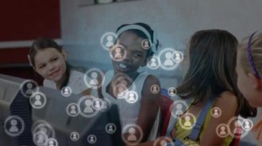 Okuldaki bilgisayarları kullanarak çeşitli mutlu öğrencilerin üzerinde beliren simgelerin canlandırması. ağ, bağlantılar, eğitim, öğrenme ve teknoloji konsepti dijital olarak oluşturulmuş video.