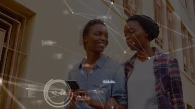 Akıllı telefonları olan mutlu Afro-Amerikan bayan arkadaşlarıyla olan bağlantıların animasyonu. Ağ, bağlantılar, iletişim ve teknoloji konsepti dijital olarak oluşturulmuş video.