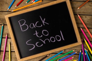 Okula geri dönen karatahta kompozisyonu ve tahta arka planda pastel boya. Okul ekipmanları, araçlar, öğrenme ve yaratıcılık kavramı.