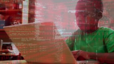 Animation of data processing over african americna boy using laptop at school. School, education and learning with technology concept digitally generated video.