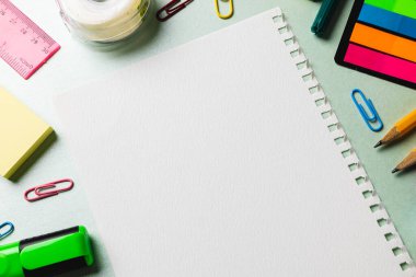 Fotokopi alanı ve yeşil yüzeyde okul aletleri olan defter kompozisyonu. Okul ekipmanları, araçlar ve yaratıcılık kavramı.