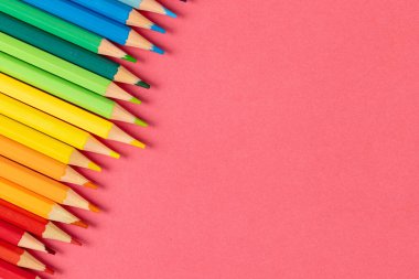 Pembe yüzeyde fotokopi alanı olan renkli boya kalemlerinin bileşimi. Okul ekipmanları, araçlar, eğitim, model ve yaratıcılık kavramı.