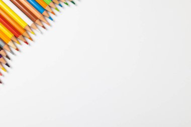 Beyaz yüzeyde fotokopi alanı olan renkli boya kalemlerinin bileşimi. Okul ekipmanları, çizim araçları ve yaratıcılık kavramı.