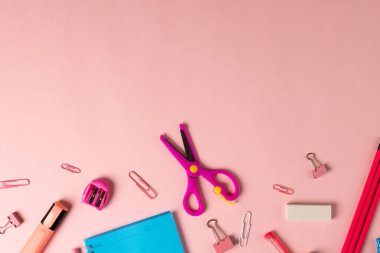 Pembe ve kırmızı okul ekipmanlarının kompozisyonu açık pembe yüzey ve fotokopi alanı. Okul ekipmanları, araçlar ve yaratıcılık kavramı.
