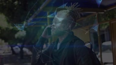 Akıllı telefon kullanan mutlu albino adam üzerinde küre ve şekillerin animasyonu. Ağ, iletişim ve teknoloji konsepti dijital olarak oluşturulmuş video.