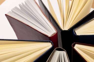 Beyaz yüzeyde duran kitaplarla birlikte merkezi kompozisyonun resmi. Okul ekipmanları, araçlar, öğrenme ve yaratıcılık kavramı.