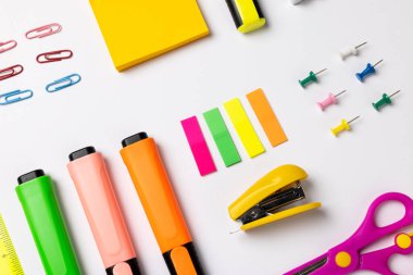 Beyaz yüzey üzerinde işaretleyiciler ve okul öğeleri olan kompozisyon resmi. Okul ekipmanları, araçlar, öğrenme ve yaratıcılık kavramı.