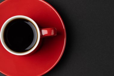 Siyah arka planda kırmızı kahve fincanı. Kahve, içecek ve içecekler..