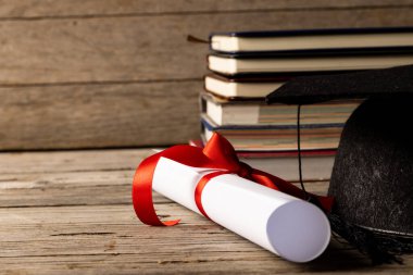 Image of stack of books and diploma on wooden surface. School equipment, tools, learning and education concept.
