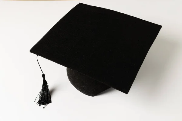 Imagen Sombrero Graduación Negro Acostado Superficie Blanca Concepto Escuela Aprendizaje — Foto de Stock