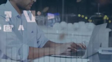 Animation of globe and numbers over biracial businessman using laptop. Business, network and technology concept digitally generated video.