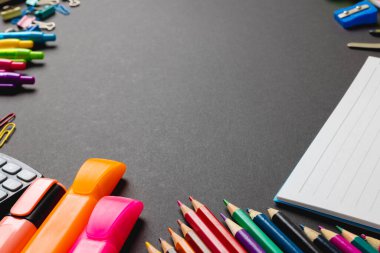 Composition of frame made of colorful school tools on grey surface with copy space. School equipment, tools and creativity concept.