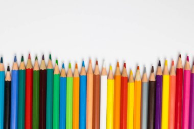 Beyaz yüzeyde fotokopi alanı olan renkli boya kalemlerinin bileşimi. Okul ekipmanları, çizim araçları ve yaratıcılık kavramı.