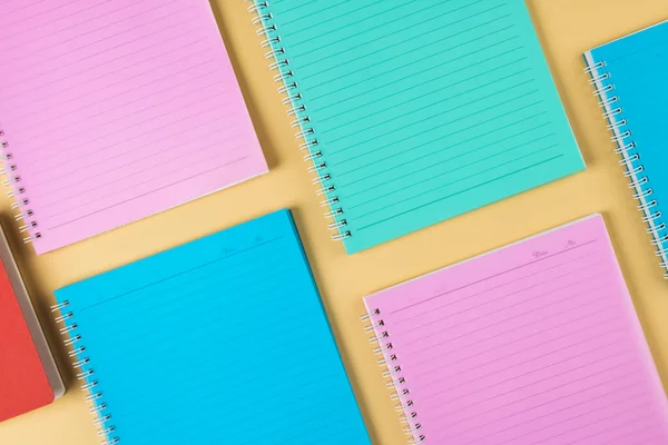 Composition Diverse Colorful Notebooks Lying Yellow Surface School Equipment Tools — Stockfoto