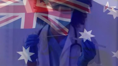 Animation of flag of australia over african american female doctor wearing face mask. Global medicine, healthcare and digital interface concept digitally generated video.