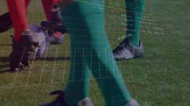 Çeşitli erkek futbol oyuncularının antrenmanlarının bacaklarının üzerinde grafikler ve finansal verilerin animasyonu. Spor, futbol, finans ve ekonomi konsepti dijital olarak oluşturulmuş video.