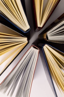 Beyaz yüzeyde duran kitaplarla birlikte merkezi kompozisyonun resmi. Okul ekipmanları, araçlar, öğrenme ve yaratıcılık kavramı.