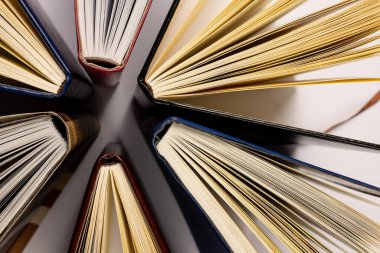 Beyaz yüzeyde duran kitaplarla birlikte merkezi kompozisyonun resmi. Okul ekipmanları, araçlar, öğrenme ve yaratıcılık kavramı.