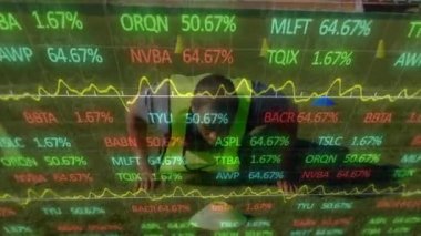 Afro-Amerikan erkek futbolcu eğitimi üzerine grafiklerin ve finansal verilerin animasyonu. Spor, futbol, finans ve ekonomi konsepti dijital olarak oluşturulmuş video.