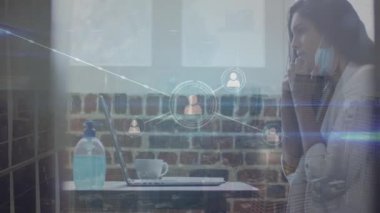 Animation of network of connections over caucasian businesswoman wearing face mask. Global business, finances, data processing and digital interface concept digitally generated video.
