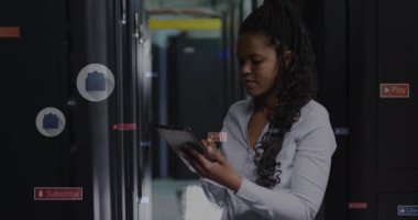Animation of social media icons and texts over african american businesswoman in server room. Global business, computing and digital interface concept digitally generated video.