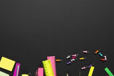 Çeşitli ofis malzemelerini düşünün, siyah arka planda iğne, cetvel, makas. Eğitim, öğrenme ve yaratıcılık.