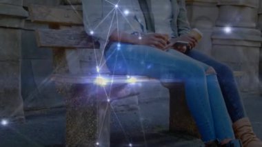 Akıllı telefonlar kullanan mutlu Afro-Amerikan ikiz kadınlar üzerindeki bağlantıların animasyonu. Aile, ilişki, bağ, iletişim ve teknoloji konsepti dijital olarak oluşturulmuş video.