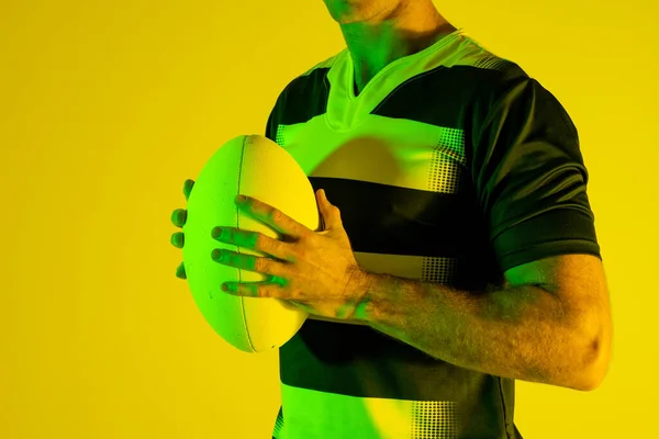 Jogador Rugby Masculino Caucasiano Com Bola Rugby Sobre Iluminação Laranja — Fotografia de Stock