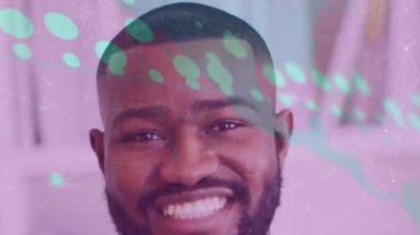 Afro-Amerikan bir adamın gülümsemesi üzerine veri işleme animasyonu. Küresel tıp ve dijital arayüz kavramı dijital olarak oluşturulmuş video.
