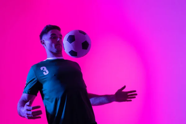 Caucasian Male Soccer Player Playing Football Neon Pink Lighting Sport — 스톡 사진
