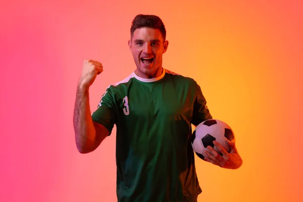 Portrait Happy Caucasian Male Soccer Player Raising Hand Football Neon — Stock fotografie