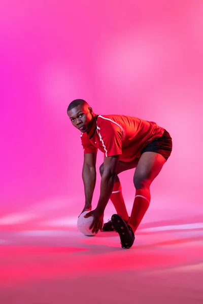 African American Male Rugby Player Catching Rugby Ball Pink Lighting — Photo