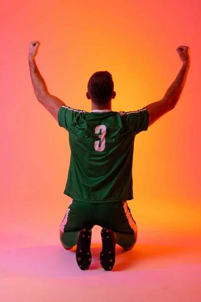 Caucasian Male Soccer Player Raising Hands Neon Pink Lighting Sport — 스톡 사진