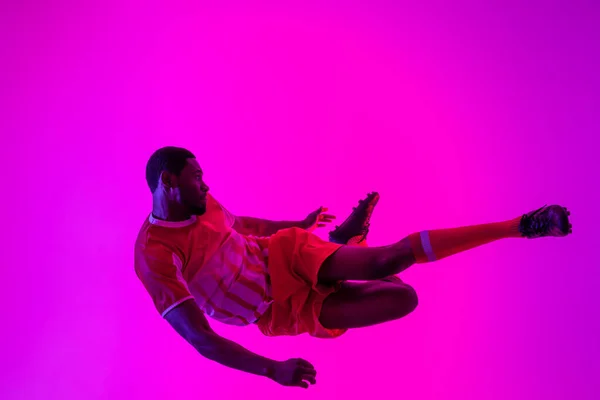 African American Male Soccer Player Jumping Neon Pink Lighting Sport — Fotografia de Stock