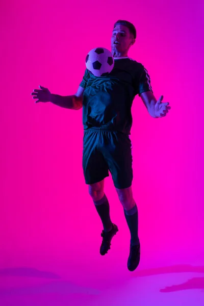 Caucasian Male Soccer Player Playing Football Neon Pink Lighting Sport — 图库照片