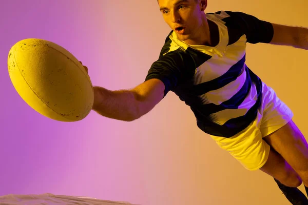 Белый Игрок Регби Прыгает Мячом Регби Через Розовое Освещение Спорт — стоковое фото