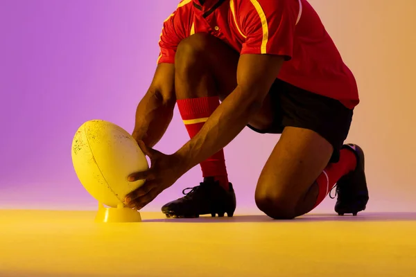 African American Male Rugby Player Crouching Rugby Ball Pink Lighting — Photo