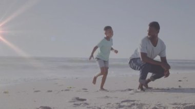 Afrika kökenli Amerikalı bir adam ve oğlunun plajda birlikte oynadığı animasyonlar. Yaşam tarzı, aile ve ışık konsepti dijital olarak oluşturulmuş video.