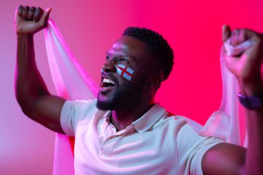 Image of happy african american male soccer fan with flag of england in neon pink lighting. Sport, fans, cheering and emotions concept.