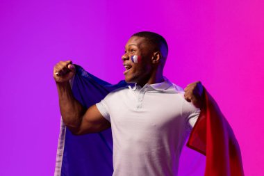 Happy african american male supporter with flag of france over pink lighting. Sport, movement, training and active lifestyle concept.