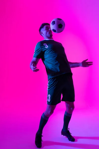 Caucasian Male Soccer Player Playing Football Neon Pink Lighting Sport — Foto Stock
