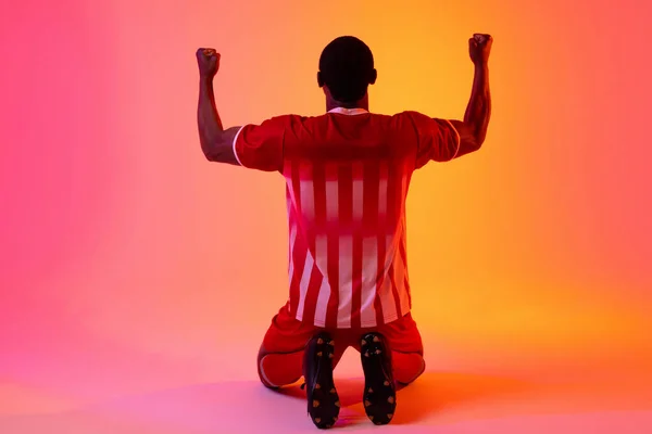 African American Male Soccer Player Raising Hands Neon Pink Lighting — 图库照片
