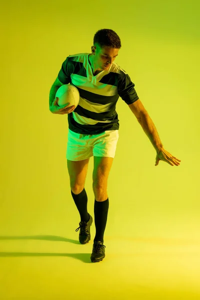 Caucasian Male Rugby Player Rugby Ball Yellow Lighting Sport Movement — Stock fotografie