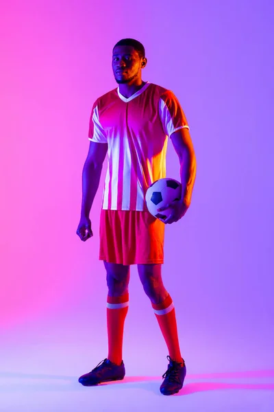 Портрет Африканского Американского Футболиста Футбольным Мячом Над Неоновым Розовым Освещением — стоковое фото