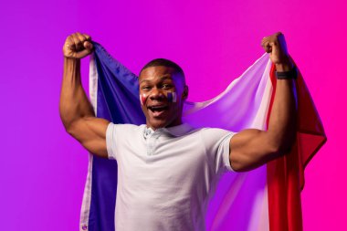 Portrait of happy african american male supporter with flag of france over pink lighting. Sport, movement, training and active lifestyle concept.