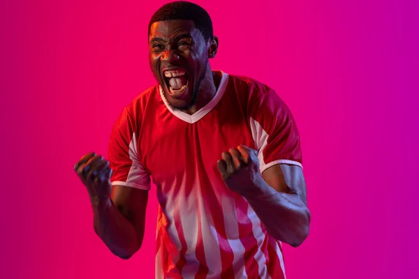 Happy African American Male Soccer Player Raising Hands Neon Pink — Stockfoto