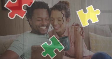 Tabletli melez bir çiftin renkli yapbozunun animasyonu. Otizm farkındalığı ayı ve dijital olarak oluşturulan kutlama konsepti.